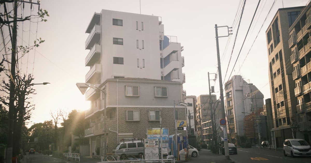 夕方の住宅街の通り沿いに並ぶ集合住宅