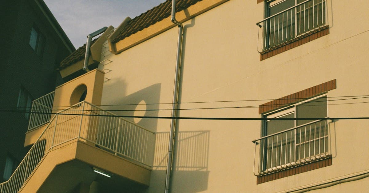 バルコニーが並ぶ黄色い外壁の集合住宅