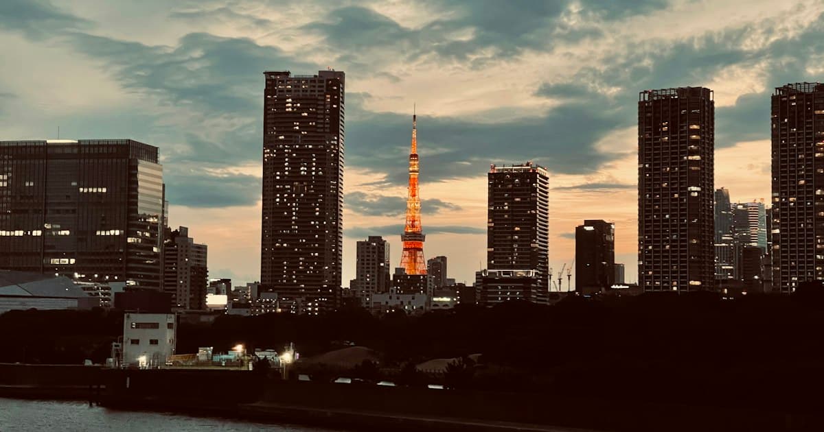 夕暮れの水辺から見た高層ビルが並ぶ都市の景色