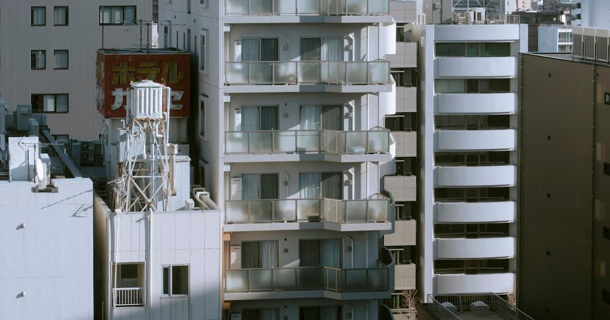 晴れた日に並ぶ中高層の集合住宅とビル(イメージ)